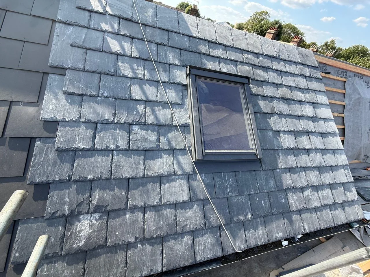 Completed natural slate roof with roof window