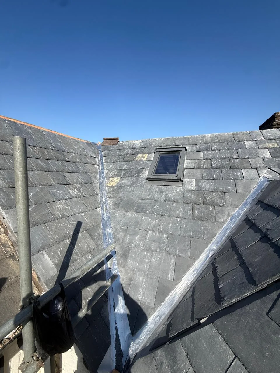 Completed slate roof pitches, valley and roof-window detailing